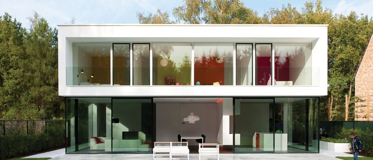 Villa luxueuse blanche avec jardin verdoyant.