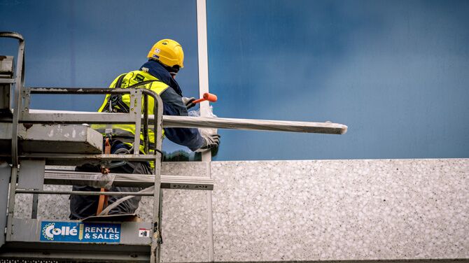 Façade specialist installing curtain walls on a high-rise building.