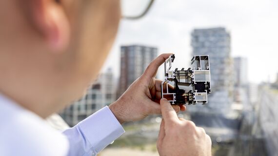 Man holding and pointing at aluminium section sample.