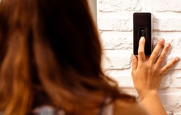 Girl entering white private home by scanning her fingerprints.