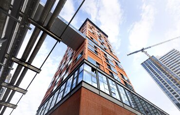 Un immeuble de grande hauteur orange vu d’en bas.
