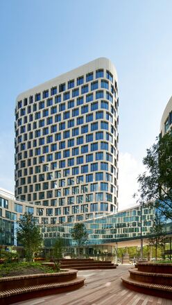 Futuristic white office building with trees next to it.